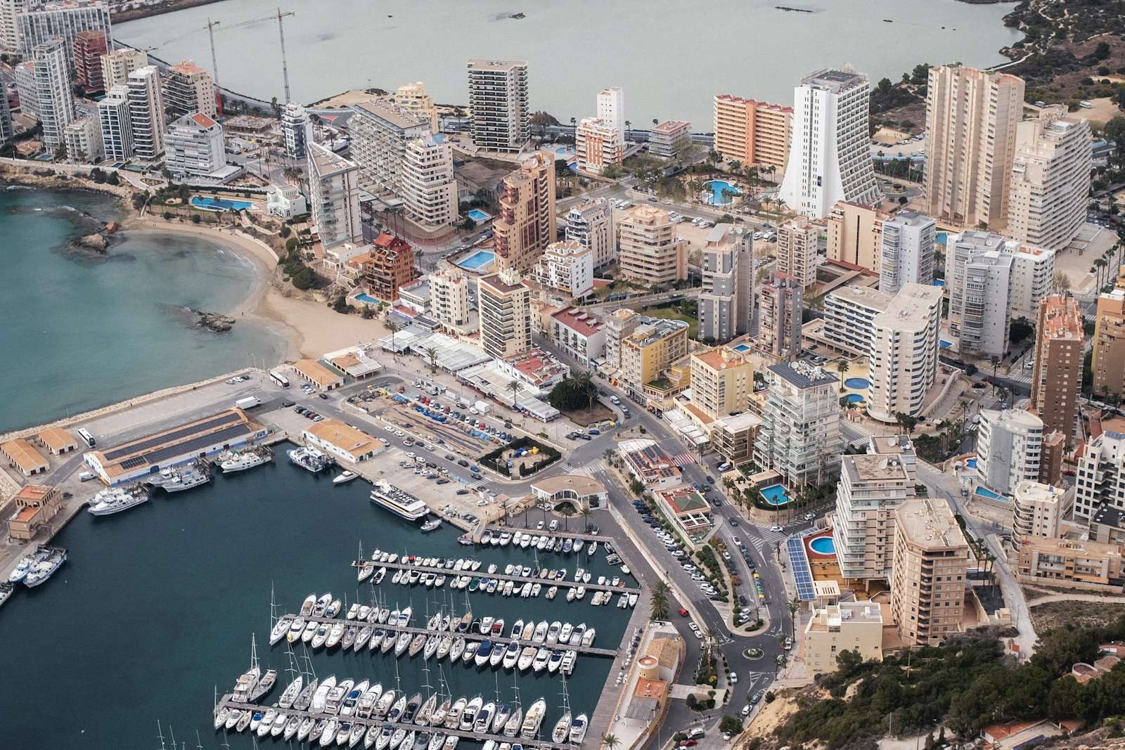 Luchtfoto van het strandfront, de haven en de appartementstorens van Calpe rond de Peñón de Ifach