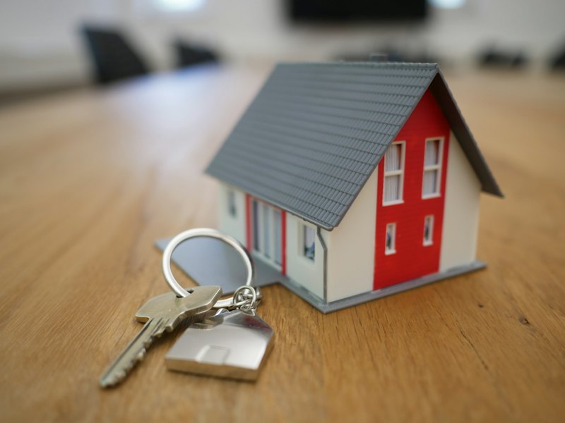 Hand die huissleutels vasthoudt met een huisvormige sleutelhanger